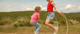 Children jumping rope in a field