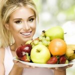 Девушка держит блюдо с фруктами и ягодами