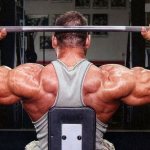 Performing overhead presses to pump up the shoulder muscles